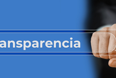 Una mano señala una lupa sobre la palabra 'Transparencia' escrita en un fondo azul.